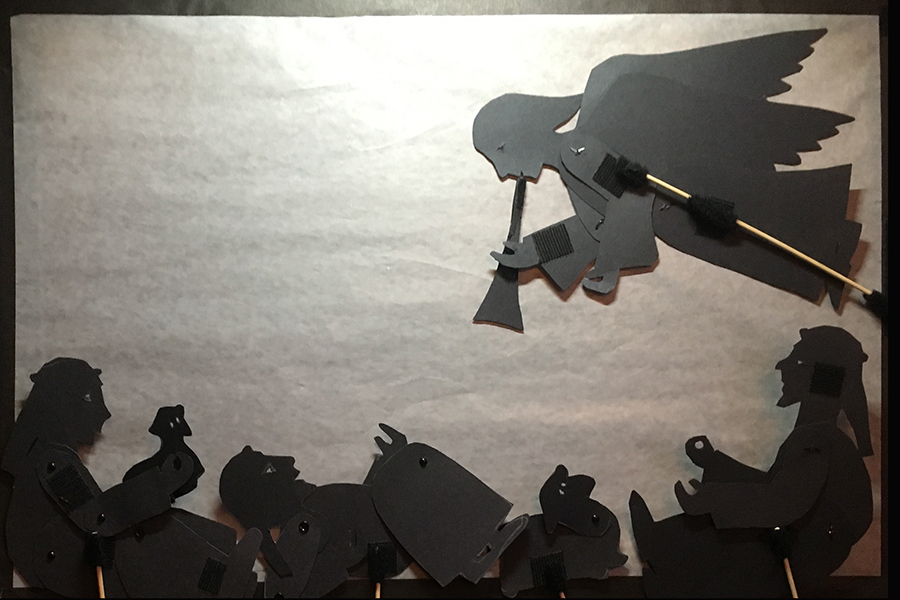 Shadow puppets of angel waking up the shepherds to tell the news about Jesus' bir