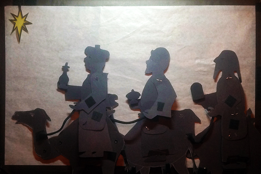 Shadow puppets of three wise men on camels following the star