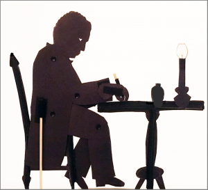 Shadow puppet of William Still writing "The Underground Railroad"