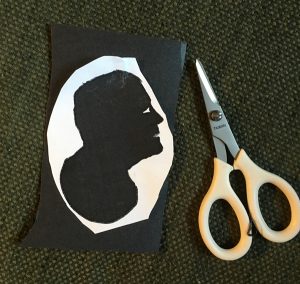 Demonstration how to cut out a silhouette by taping it to poster board