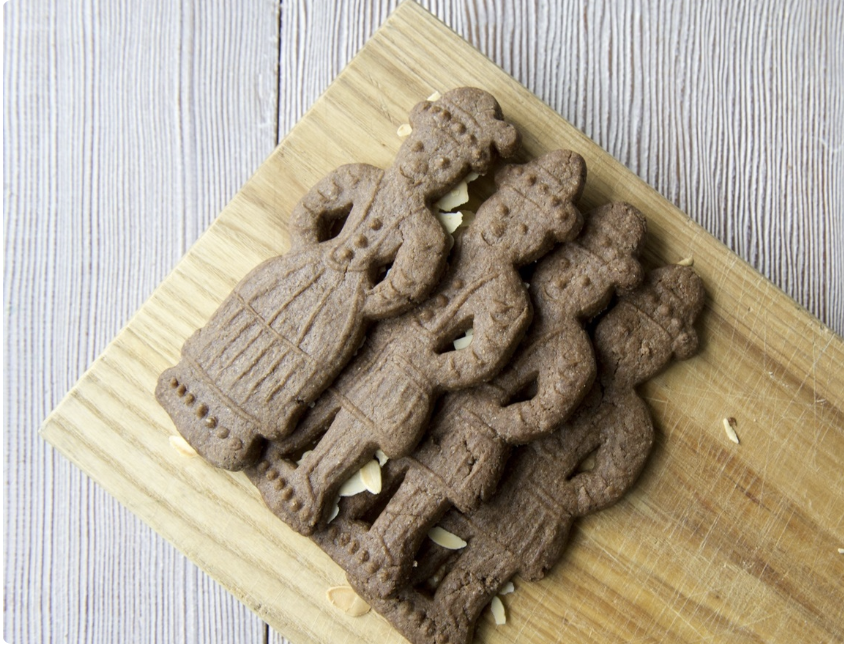 four speculaas figurines on wooden plank