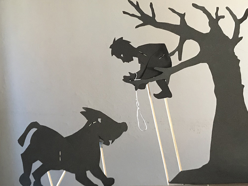 Silhouettes of Peter in a tree trying to catch the wolf with a rope