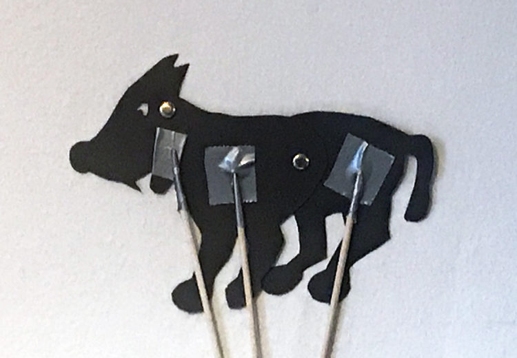 Silhouette puppet of a wolf with movable jaw, front and back