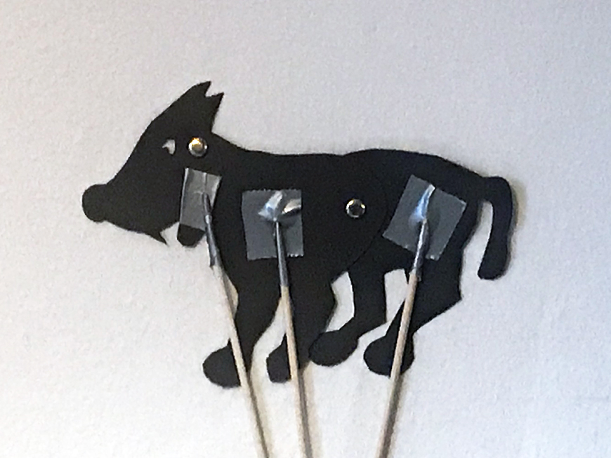 Silhouette puppet of a wolf with movable jaw, front and back