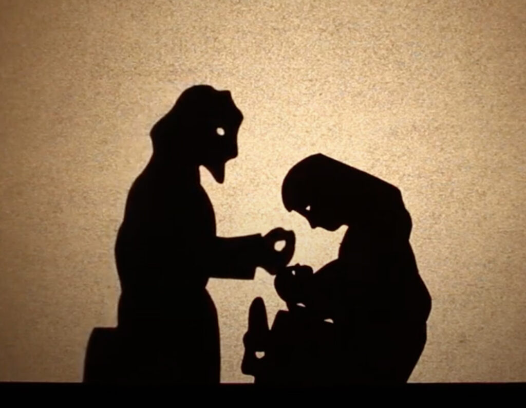 Shadow puppets of Mary holding Jesus and Joseph caressing his head