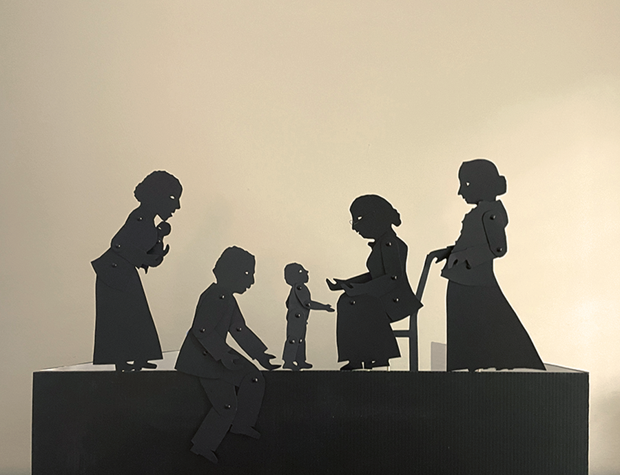 Silhouette puppets of a young mother holding a baby, a father on his news with his toddler son, and two older white ladies ng black family and two older ladies, one sitting on a chair