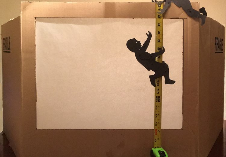 shadow puppets measuring a cardboard box theater