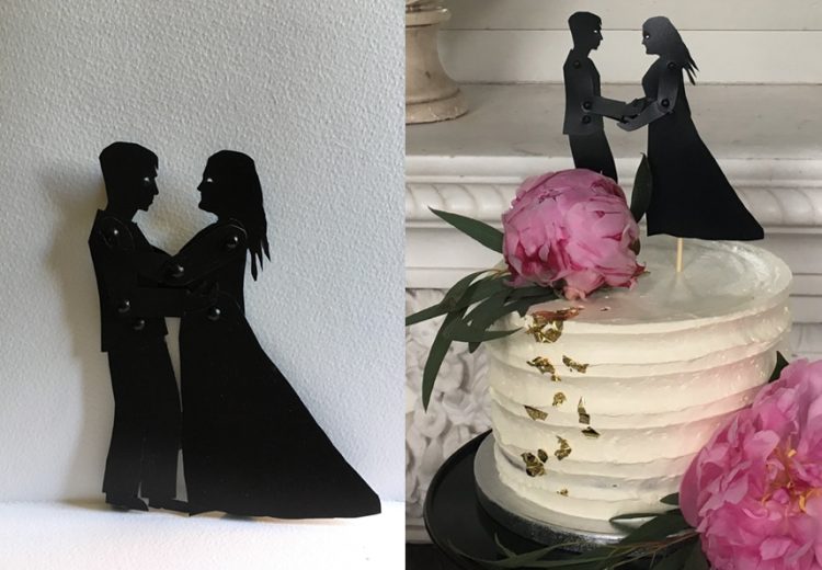 Small shadow puppets holding hands and embracing with wedding cake