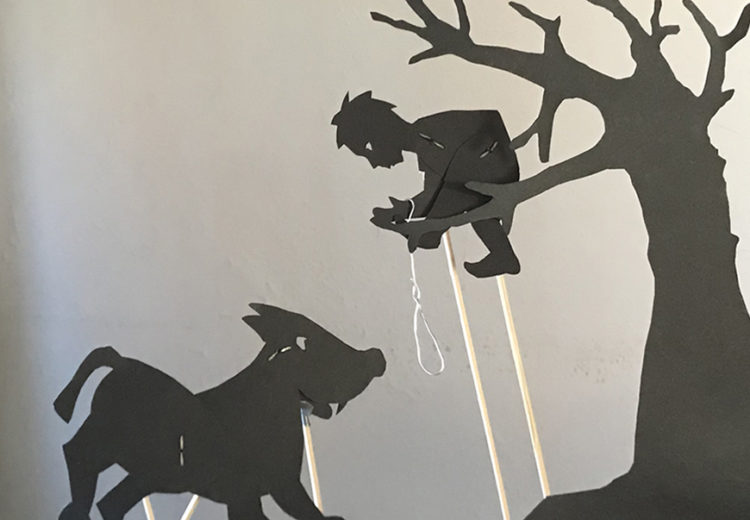 Silhouettes of Peter in a tree trying to catch the wolf with a rope